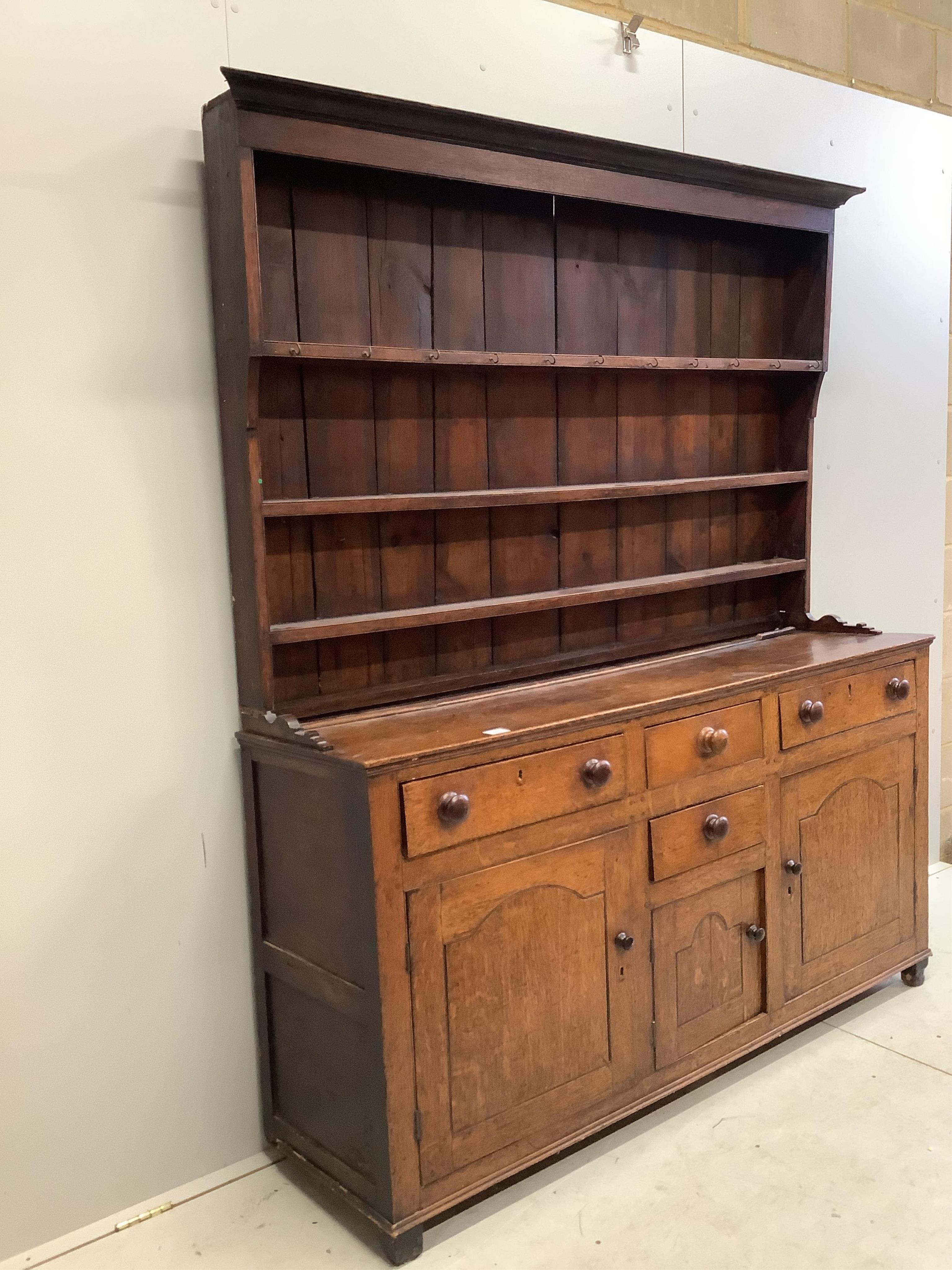 A George III oak dresser with boarded rack, width 168cm, depth 46cm, height 204cm. Condition - poor, lacks back legs